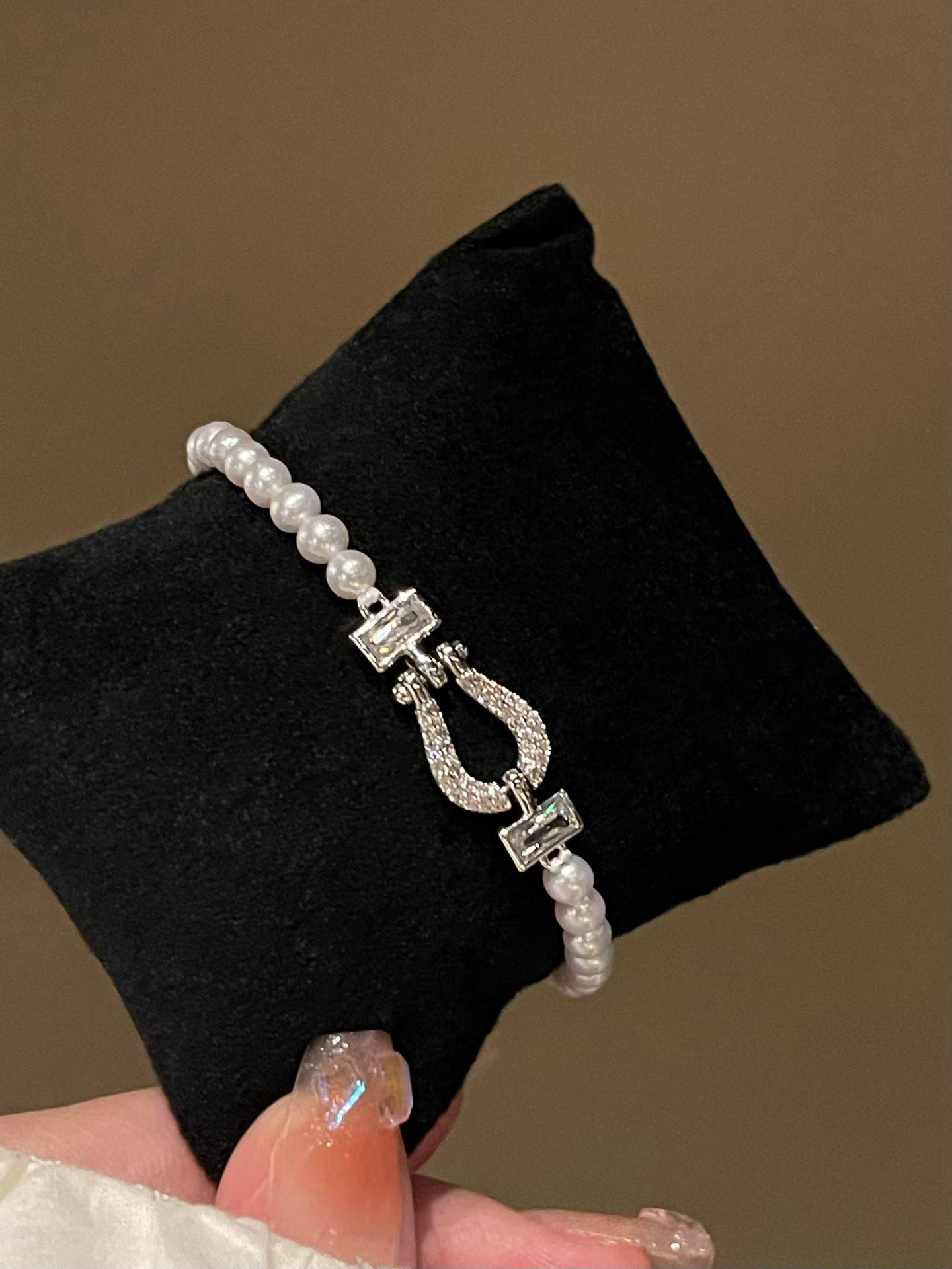 Freshwater pearl bracelet with a silver clasp on a black display block